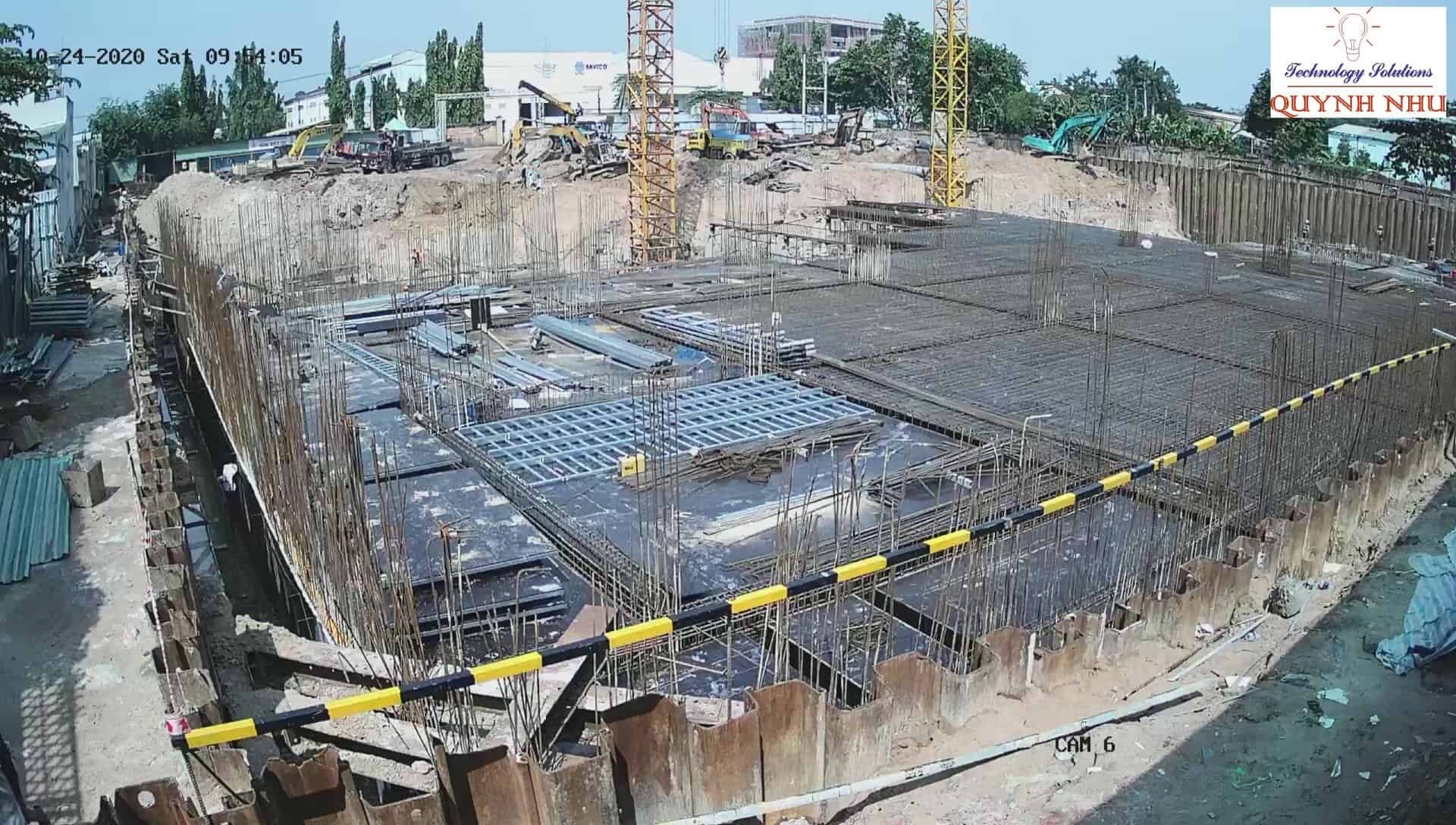 Toàn cảnh công trường thi công với cần cẩu tháp và khu vực đổ móng bê tông cốt thép.