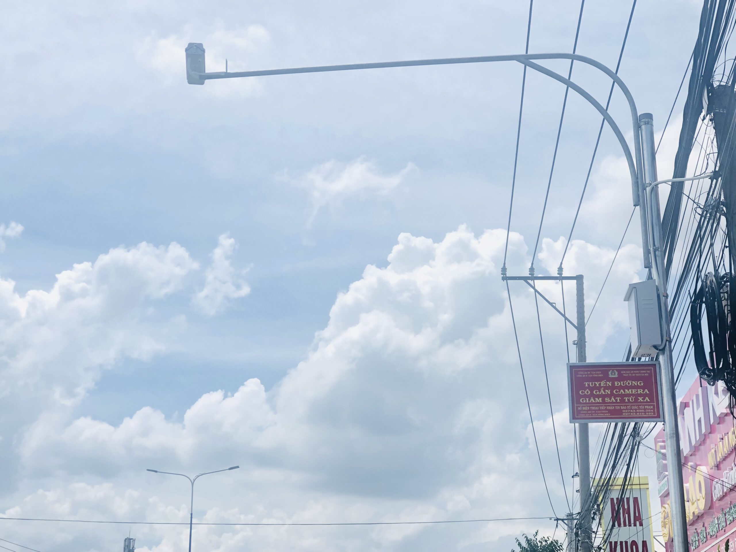 Camera an ninh giám sát lắp trên cột đèn gần cửa hàng nha khoa.