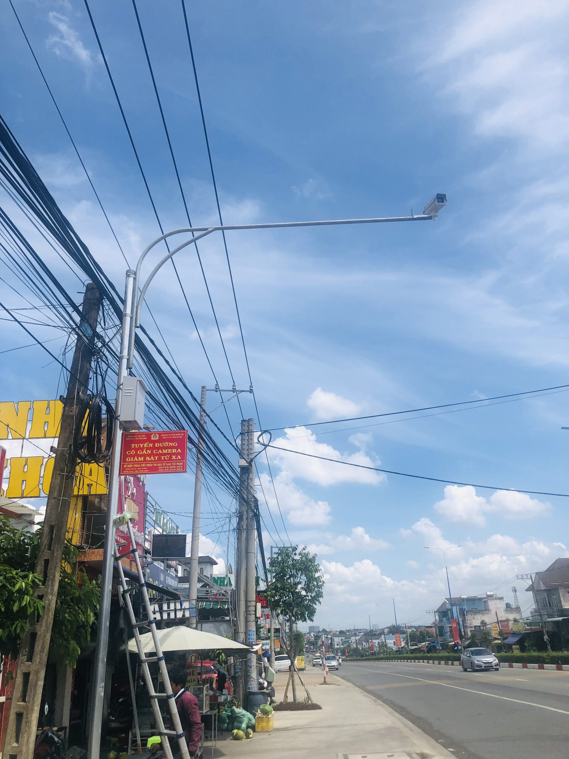 KTV dựng thang thi công lắp đặt camera trên cột đèn ven đường.