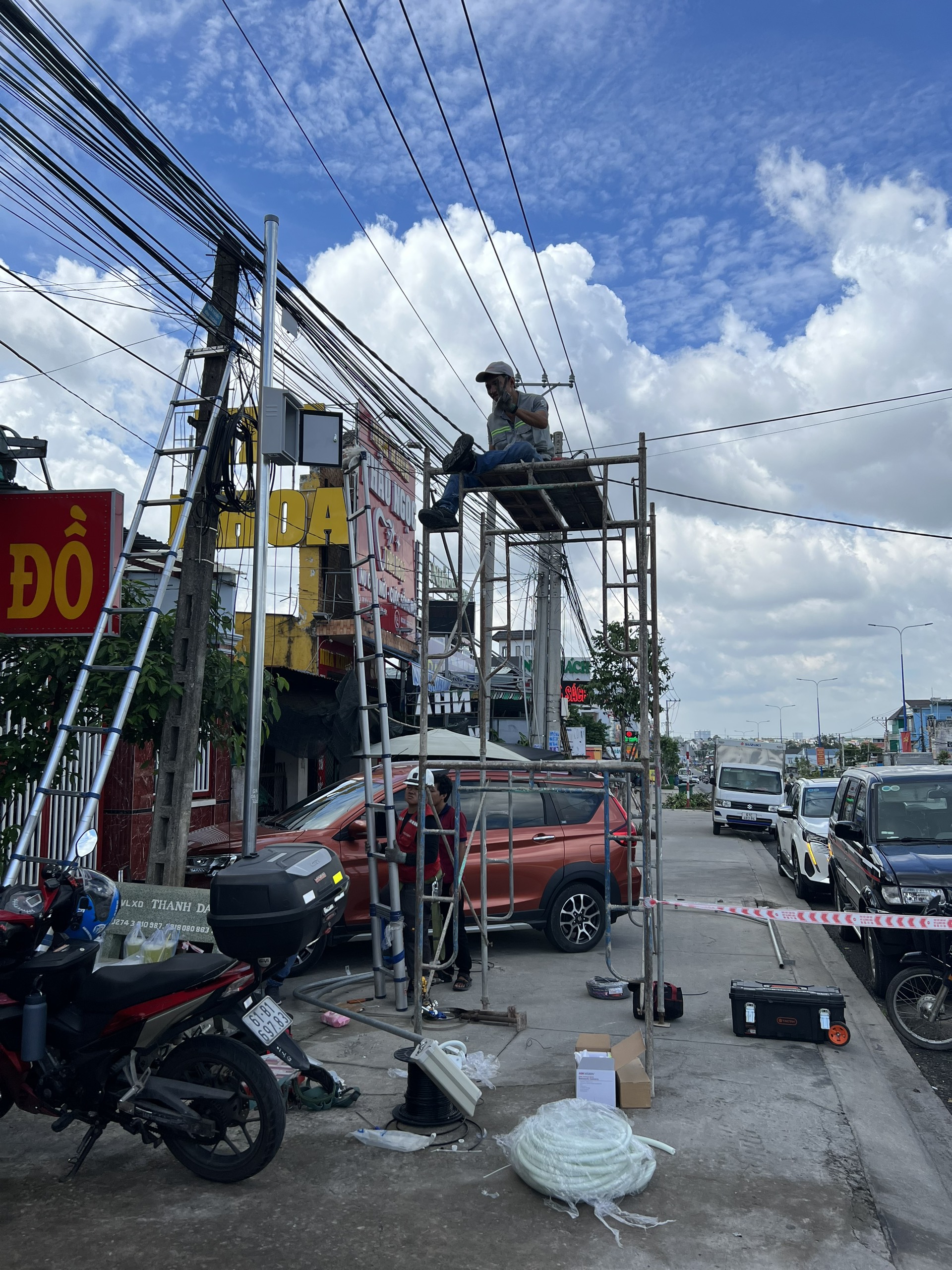 KTV ngồi trên giàn giáo thi công lắp đặt camera ven đường.