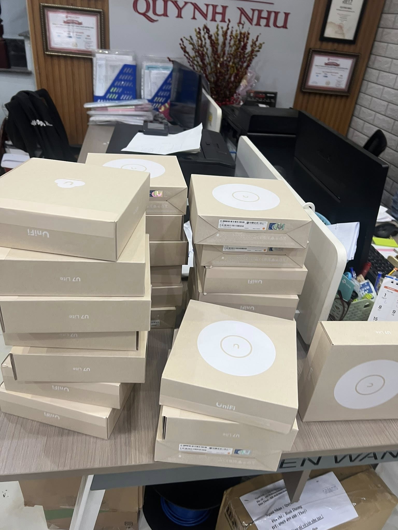 Các hộp Access Point xếp chồng trên bàn làm việc.